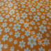 White ditsy flower on Orange 100% Cotton